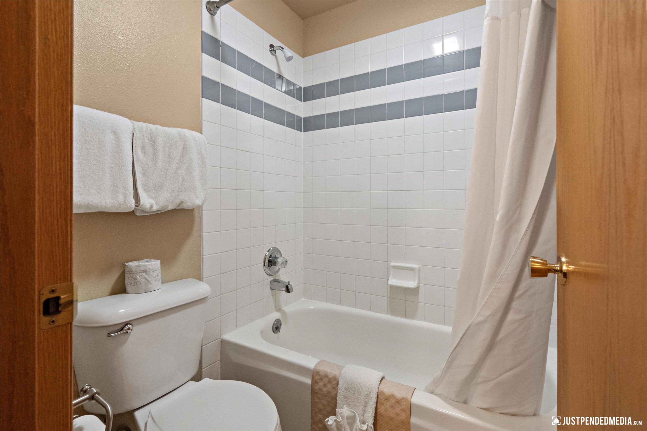 A clean a modern bathroom with linens and tiled shower